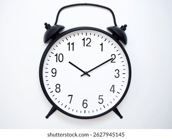Black Retro Alarm Clock Showing 10:10 or 22:10. Classic Bell Style on White Wood Background.
