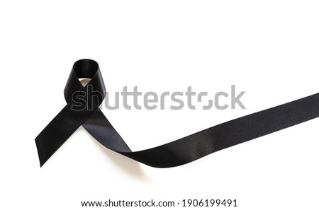 Black ribbon showing symbol of remembrance or mourning for mass grief incident over white background with copy space