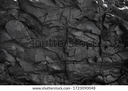 Black rock, stone, textured. Background for design. Hard light.