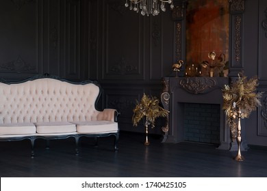 Black room interior with a vintage sofa, chandelier, mirror and fireplace - Shutterstock ID 1740425105