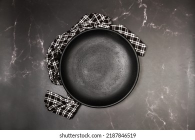 Black Round Flat Plate On A Black Marble Kitchen Counter In A Top View