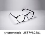 Black round frame glasses facing right side and isolated on white background. Minimalist glasses display with copy space for text with 45 degree shot.