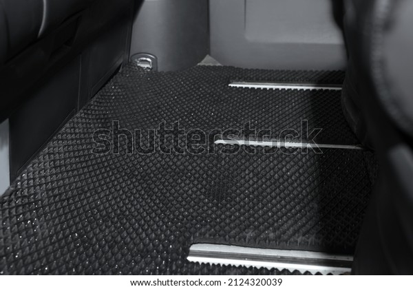 Black rubber car
floor mat in auto,
closeup