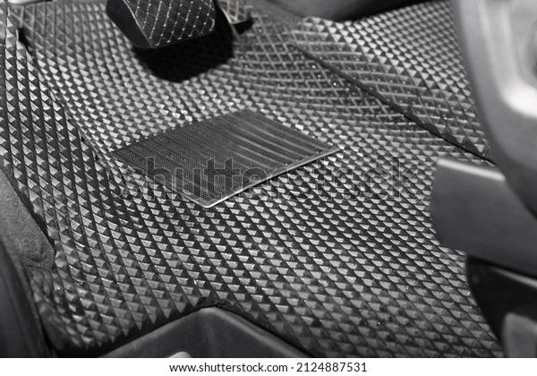 Black rubber car\
floor mat in auto,\
closeup