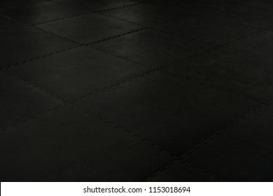 Black Rubber Floor Mat And Tiles Inside A Gym. Black Rubber Fitness Floor Texture And Background. EPDM Safety Mats Reduce The Injury Risk Caused By Falls On Playgrounds And Sport Facilities.