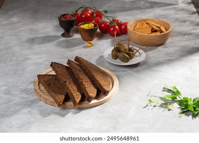 Black rye bread is cut into portions and lies on a wooden plate