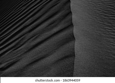 Black Sand Dune. Black Sand Beach Macro Photography. Background, Texture, Wave Pattern Of Oceanic Sand On The Beach, Black. Texture Of Beach Sand. Black Beach.