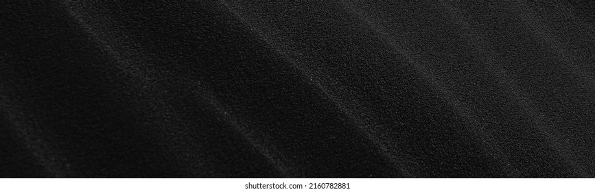 Black Sand dune. Black Sand beach macro photography. Background, texture, wave pattern of oceanic sand on the beach, black. Texture of beach sand. Black beach.