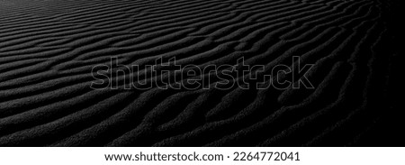 Black sand waves as background. Panaroma Sand texture. abstract texture line wave. Sand Waves Abstract Black and White background. Volcanic rock texture. Black salt. Black Sand. Sea Beach.