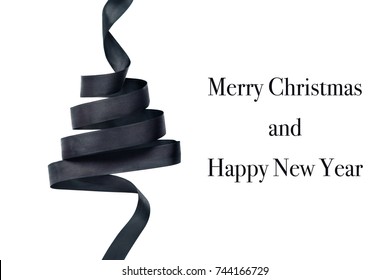 Black satin ribbon in shape of Christmas tree. Isolated on white background. Merry Christmas and Happy New Year text