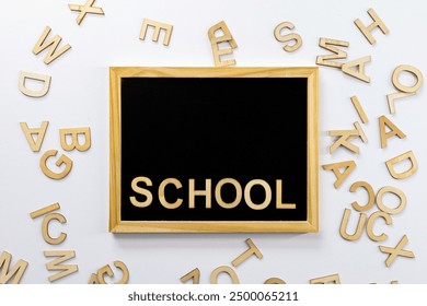 Black school blackboard with "Back to School" inscription in wooden letters. Scattered letters side by side. Top view. For backgrounds and presentations - Powered by Shutterstock