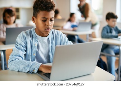 Black schoolboy using laptop during computer class at school. - Powered by Shutterstock