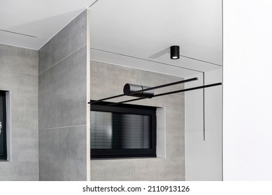 Black Sconce Mounted In A Large Mirror In The Bathroom, Visible LED Lighting In The Shape Of A Tube.