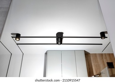 Black Sconce Mounted In A Large Mirror In The Bathroom, Visible LED Lighting In The Shape Of A Tube.