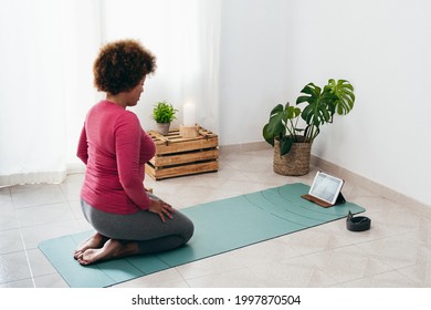 Black Senior Woman Doing Yoga Remote Class Meditation At Home - Sport And Healthy Lifestyle Concept - Focus On Tablet