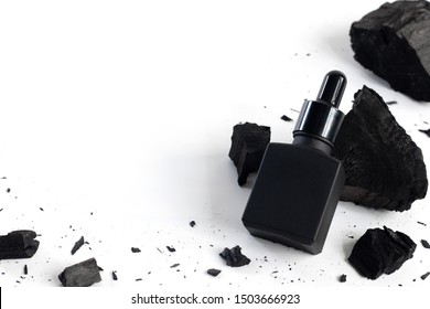 Black Serum Bottle With Charcoal On White Background, Mockup Product