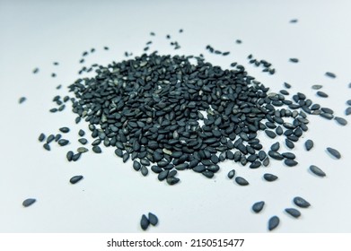 Black Sesame Seeds Scattered On A White Background