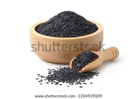 Black sesame seeds with wooden bowl and scoop isolated on white background.