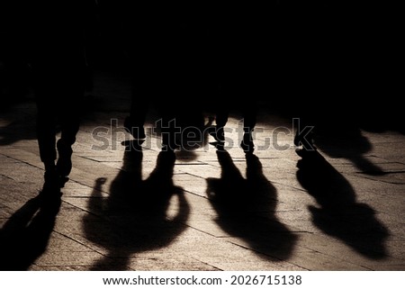 Black shadows and silhouettes of people on the street. Crowd walking down on sidewalk, concept of pedestrians, crime, society, population