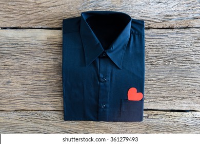 Black Shirt And Red Heart In Pocket On Wooden Background