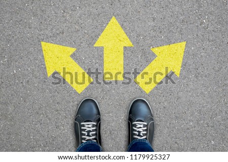 Black shoes standing at the crossroad making decision which way to go - three ways to choose.