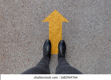 Black Shoes Standing On The Asphalt Concrete Floor With Yellow Arrow. Feet Shoes Walking In Outdoor. Youth Selphie Modern Hipster