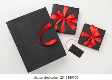 Black shopping bag and gift boxes on color background, top view.Black Friday concept - Powered by Shutterstock