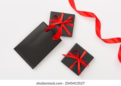 Black shopping bag and gift boxes on color background, top view.Black Friday concept - Powered by Shutterstock