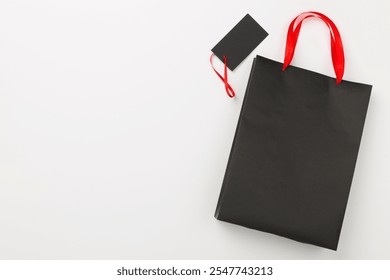 Black shopping bag and gift boxes on color background, top view.Black Friday concept - Powered by Shutterstock