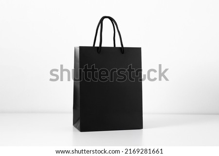 Black shopping bag on white background. Black paper bag with handles.