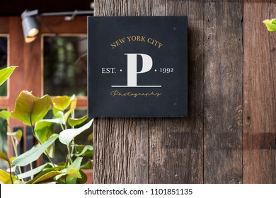 Black signage on a rustic wooden wall mockup - Shutterstock ID 1101851135