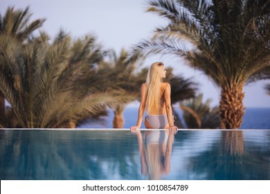 Black Silhouette Of Happy Woman On Summer Beach Holiday Relaxing In Luxury Spa Hotel In Infinity Swimming Pool With Blue Sea View. Healthy Lifestyle, Family Travel Background. Tropical Island Tour.