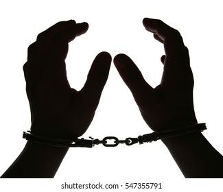 Black Silhouette Of Man Hands In Handcuffs On Light Background