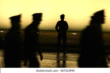 Black Silhouette On Wall Background Of A Uniformed Police Officer, Style Photo Blur