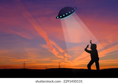 black silhouette of ufo spaceship, man, earthling in rays of light, dramatic, disturbing situation, concept aliens arrived on flying saucer, mysterious disappearance of people, paranormal phenomena - Powered by Shutterstock