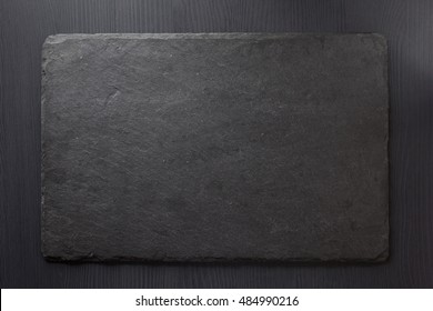 Black Slate Stone On Wooden Background