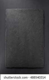 Black Slate Stone On Wooden Background