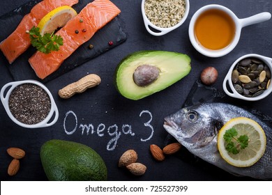 Black slate table with product rich in omega 3 and vitamin D. Written word omega 3 by white chalk. - Shutterstock ID 725527399
