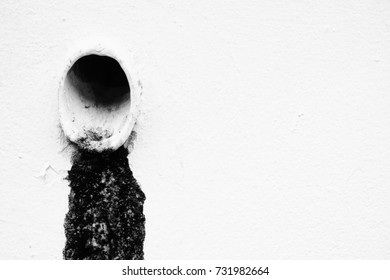 Black Sludge From Drain With White Paint Concrete Background.