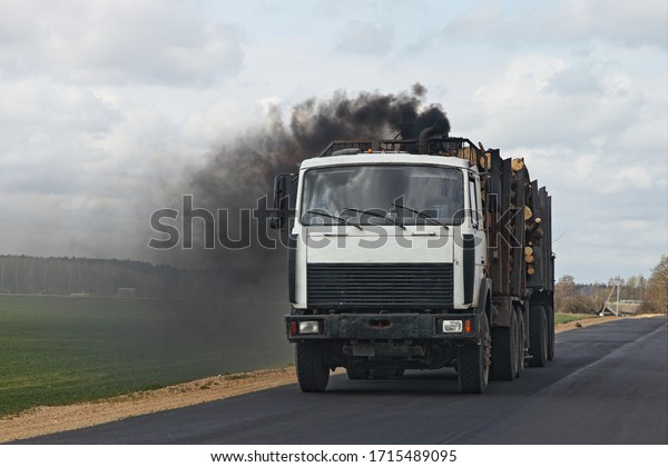 Black smoke from\
the exhaust pipe of a diesel timber truck, harmful emissions from\
vehicles ecologe problem