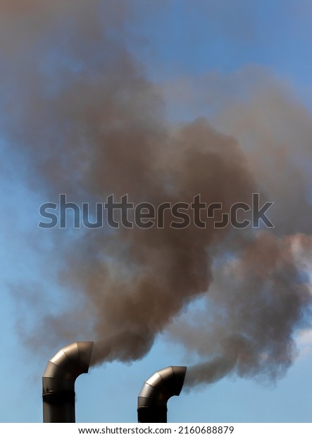 Black smoke from two truck\
exhausts