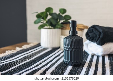 Black Soap Dispenser In A Stylish Scandinavian Bathroom Against The Background Of Towels.