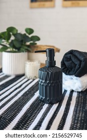 Black Soap Dispenser In A Stylish Scandinavian Bathroom Against The Background Of Towels.