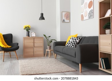 Black sofa and armchair in interior of light living room - Shutterstock ID 2078881843
