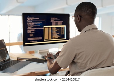 Black software developer working on computer, testing code of new application
