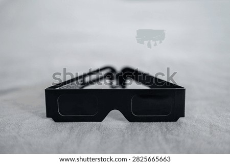Black solar eclipse viewing glasses with dark protective lenses, designed for observing the sun during a solar eclipse. Astronomy accessory for safe solar observation 