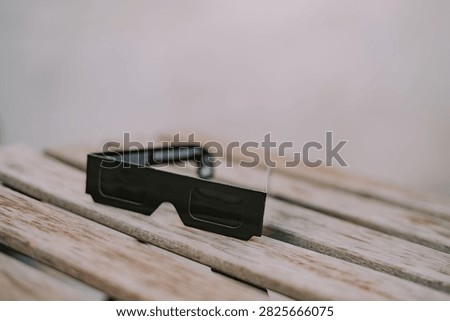 Black solar eclipse viewing glasses with dark protective lenses, designed for observing the sun during a total eclipse. Astronomy accessory for safe solar observation 