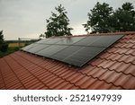 Black solar panels on a red tile roof