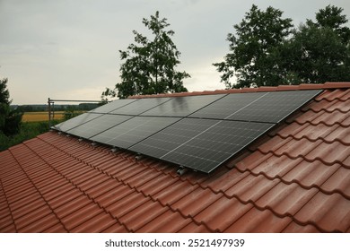 Black solar panels on a red tile roof