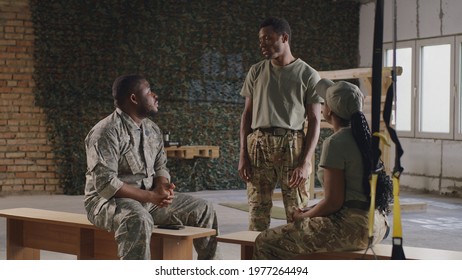 Black soldier talking with squadmates in gym - Powered by Shutterstock